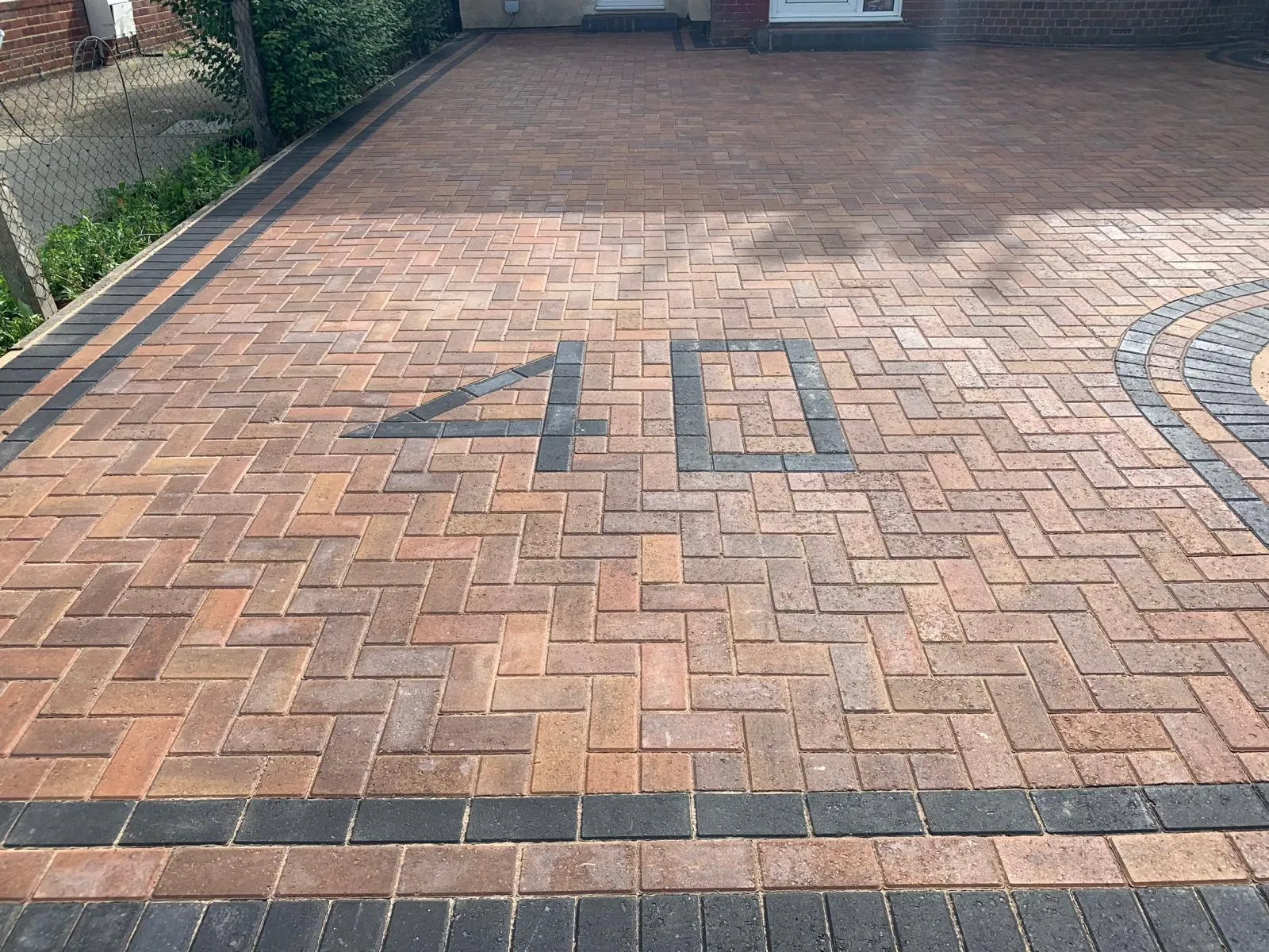 A brick driveway with a clock on it.