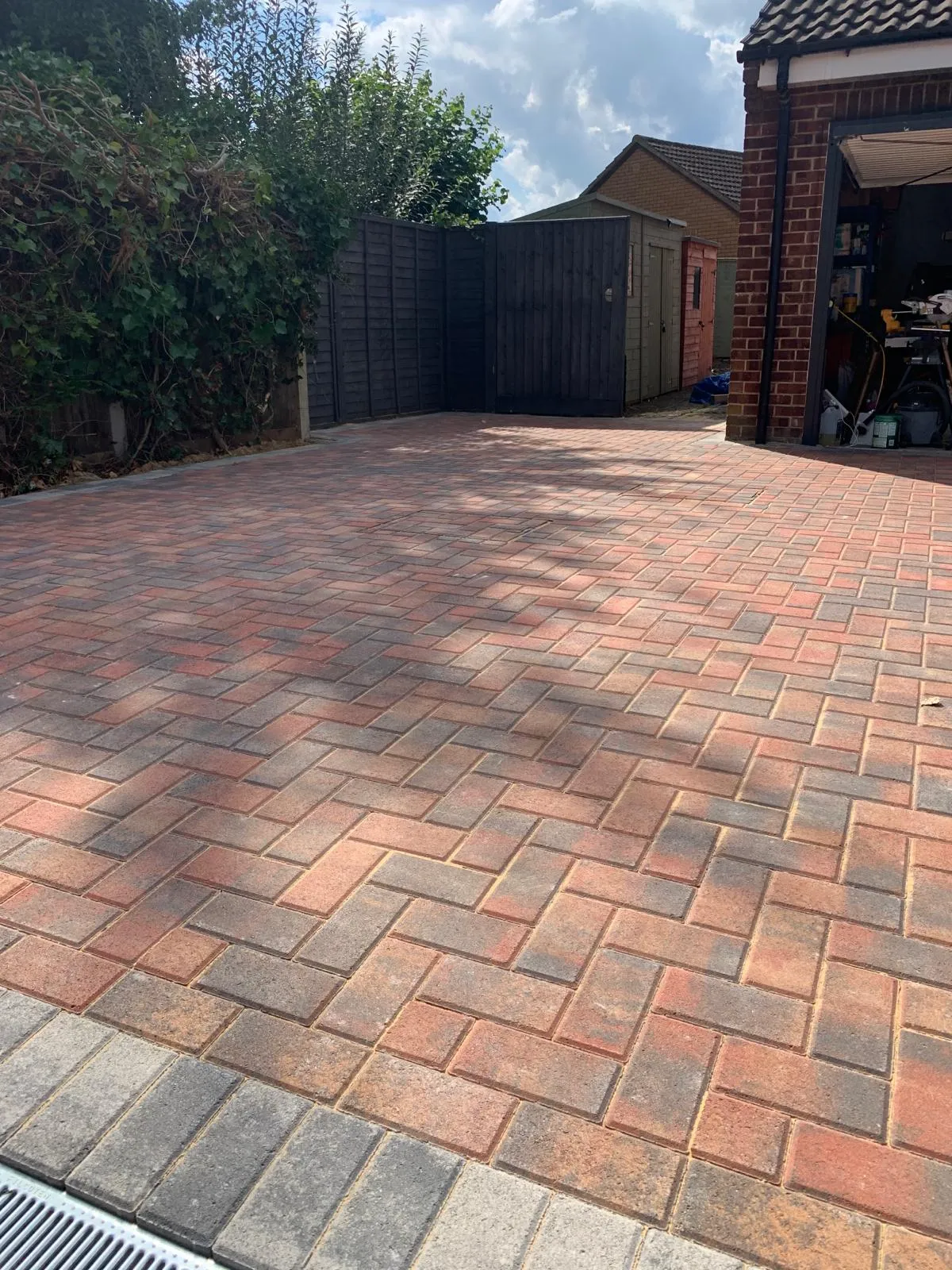 A brick driveway with a garage in the background.